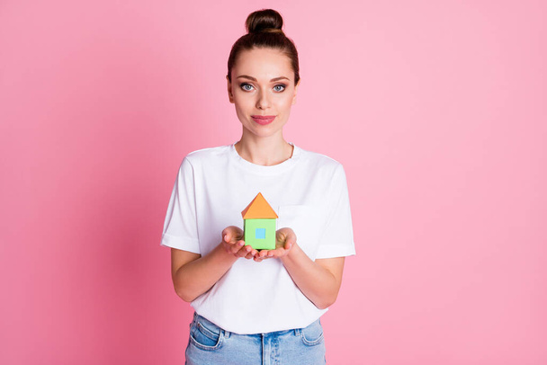 Photo of attractive lady pretty bun hold hands little paper house real estate property dream home personal paradise wear white t-shirt denim skirt isolated pastel pink color background - Foto, immagini