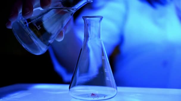 Een vrouwelijke wetenschapper voert een fotochemische reactie uit in een chemisch laboratorium voor farmaceutisch onderzoek - Video