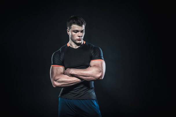Sexy young athlete posing on a black background in the Studio. Fitness, bodybuilding - Φωτογραφία, εικόνα