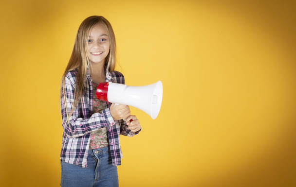 little girl, with megaphone, yellow background, scream - Zdjęcie, obraz