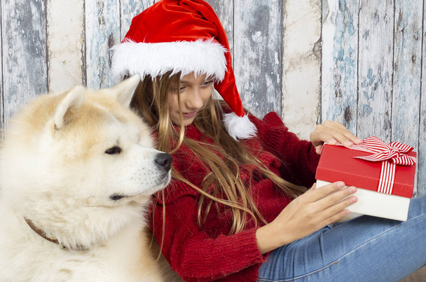 girl with her dog opening gifts at christmas - Photo, Image