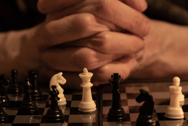 mano de anciana y ajedrez en la oscuridad, jugando ajedrez - Foto, imagen