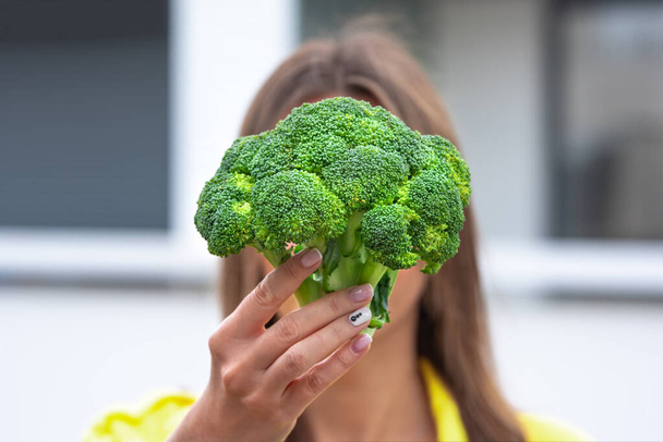 Woman holding broccoli in hands. Healthy plant based clean detox eating concept. Vegetarian, vegan, raw concept - Fotó, kép