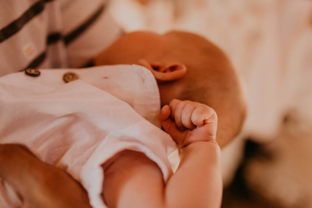 bebé mano en brazos de rito padrino de sacramento de epifanía - Foto, imagen