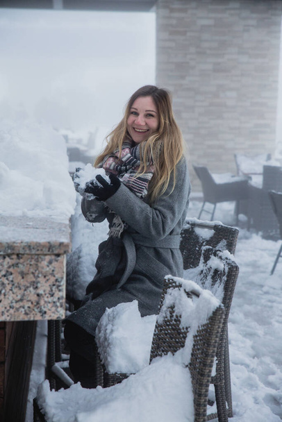 A young woman posing in a restaurant covered with snow at the cable car station, the mountain Tufandag, Gabala, Azerbaijan  - 写真・画像