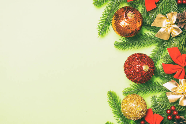 Set van feestelijke ballen, dennenboom en kerstversieringen op kleurrijke achtergrond. Bovenaanzicht van Nieuwjaar ornament concept met kopieerruimte. - Foto, afbeelding