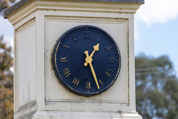 Ένα παλιό μπλε υπαίθριο ρολόι πρόσωπο με χρυσά χέρια σε λευκό φόντο - Φωτογραφία, εικόνα