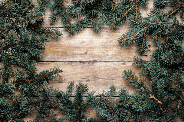 Wooden background with Christmas tree branches. Christmas banner. Copy space. - Photo, Image