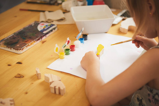 Adorable little girl painting in the room. Idea for DIY indoor activities for children. Shallow dof - Fotó, kép