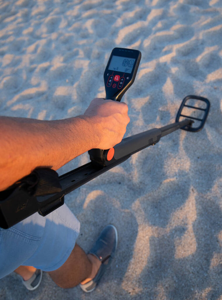 hombre utiliza el decorador de metal en la playa para buscar objetos preciosos - Foto, imagen