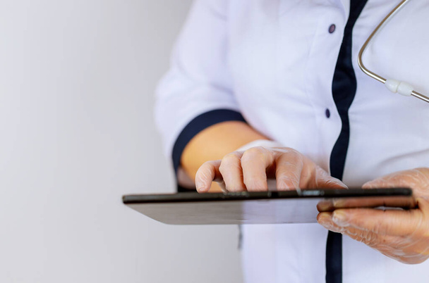 Медичний лікар, працююча жінка, використовує планшетний комп'ютер стоячи
 - Фото, зображення