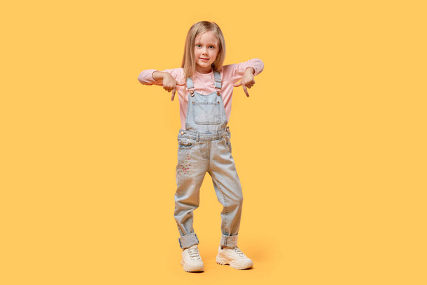 Full-length, casual clothing. The little blonde girl points her hand down. - Valokuva, kuva