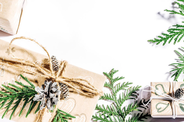 Karácsonyi háttér kézműves ajándékdobozok, clews kötél és dekorációk fenyőtobozok és gallyak fehér. Az ünnepekre való felkészülés, másolási szakasz. - Fotó, kép