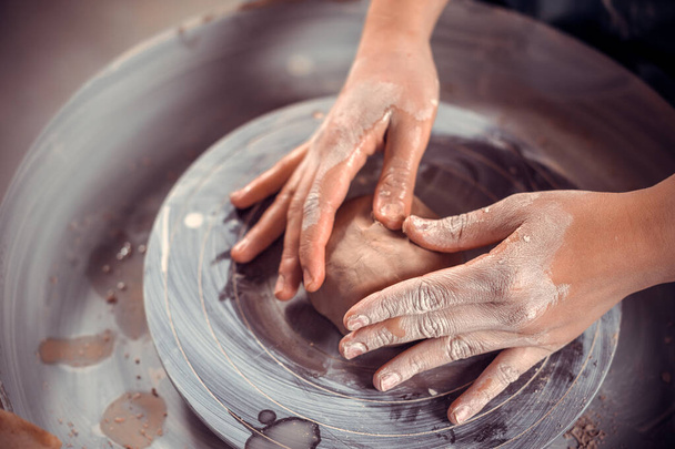 陶器のマスターは粘土や陶器のホイールで動作する方法を示しています。工芸品生産。閉鎖. - 写真・画像