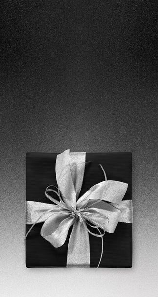 Black Friday και Cyber Monday δώρο πακέτο τυλιγμένο με ασημένια κορδέλα τόξο που απομονώνονται σε μαύρο φόντο, πρότυπο για διαφημιστική κάρτα με χώρο αντίγραφο - Φωτογραφία, εικόνα