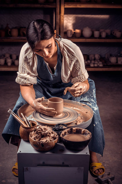 The potter works in the workshop. Hands and a potters wheel close-up. - Photo, Image