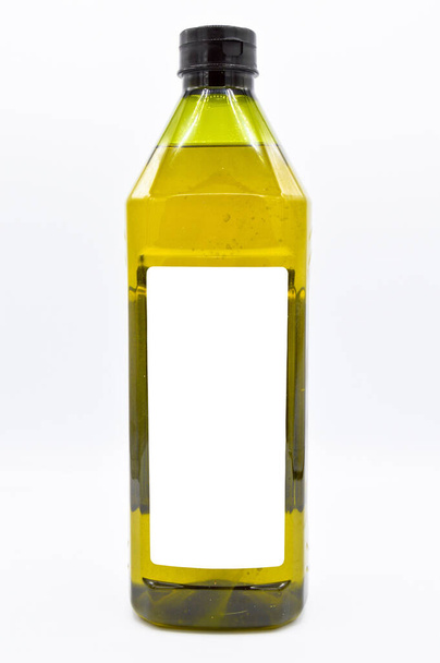 Натуральное оливковое масло упаковано в пластиковую бутылку, готовое к использованию, изолировано на белом фоне - Фото, изображение