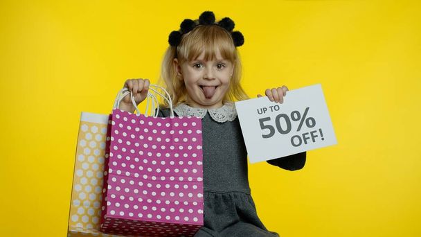 Uczeń dziewczyna z torbami na zakupy pokazuje do 50 procent off banner reklamy tekstowej. Sprzedaż wakacyjna - Zdjęcie, obraz