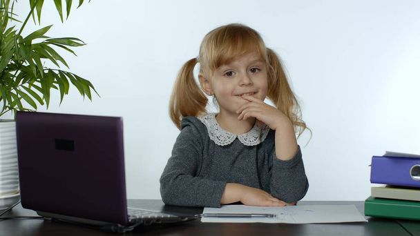 Preescolar niña distancia aprendizaje en línea en casa. Niño estudiando con computadora portátil digital - Foto, imagen