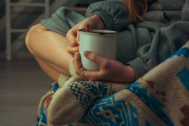 Woman resting with a cup of mulled wine in hand - Photo, image