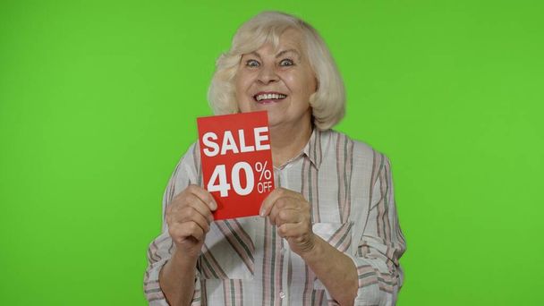 Starsza babcia pokazuje sprzedaż 40 procent off banner reklamy. Zakupy online. Czarny piątek - Zdjęcie, obraz