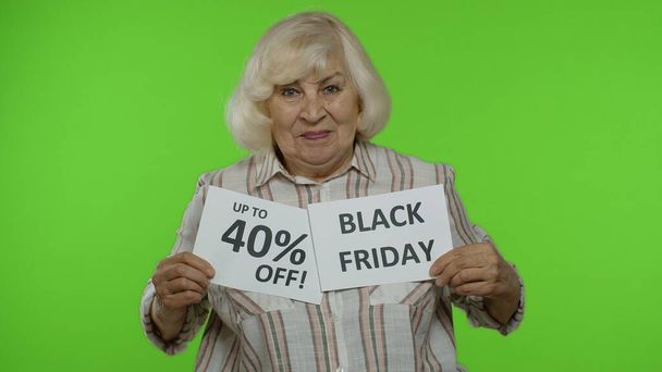 Büyük anne Kara Cuma 'yı gösteriyor, indirimli indirimli reklam yazıları yüzde 40 indirimde. - Fotoğraf, Görsel
