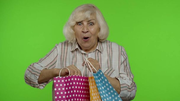 シニアおばあちゃん、お祝い、購入に満足し、割引ショッピングバッグを調達。クロマキー - 写真・画像