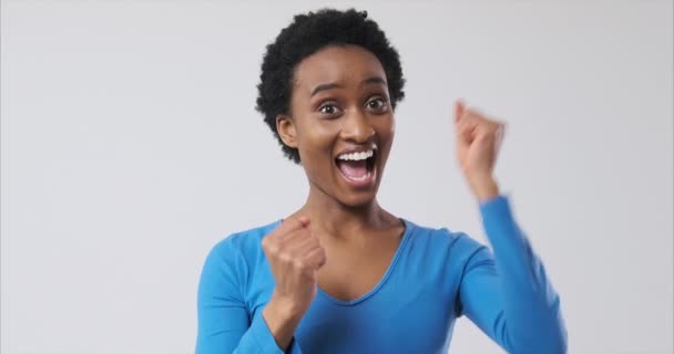 Ekstatische Frau feiert Erfolg vor weißem Hintergrund - Filmmaterial, Video