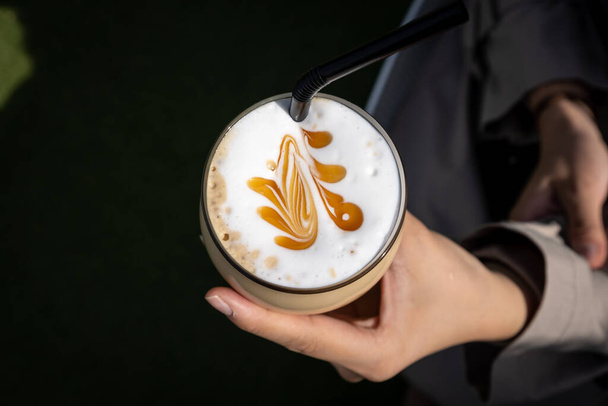 Sklenice ledového karamelového latté s jednoduchým latté uměním. Sejmuto shora dolů - Fotografie, Obrázek