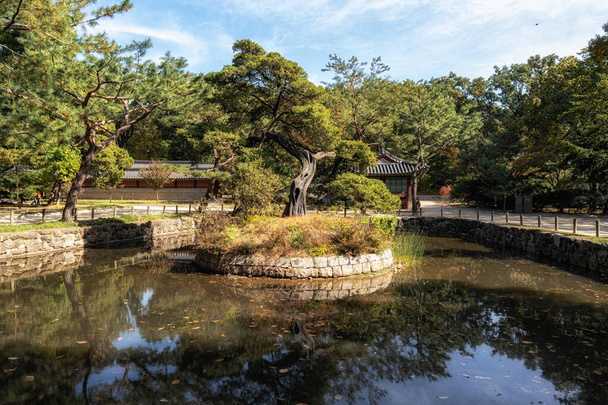 Un pequeño santuario situado cerca de la entrada con los reflejos en el agua del estanque. Tomado en Jongmyo, Seúl, Corea del Sur - Foto, imagen