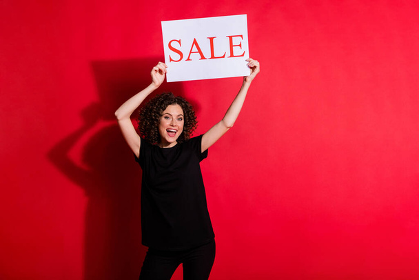 Photo of beautiful wavy hairdo person arm holding sale season placard above head isolated on red color background - Foto, immagini
