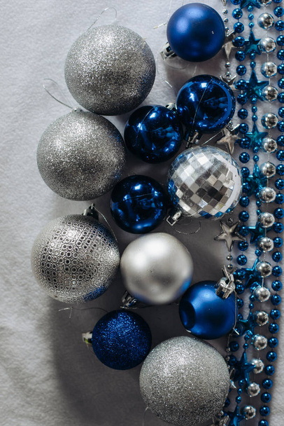 shiny and blue silver Christmas balloons and a garland on a white background with a space for text. - Foto, immagini