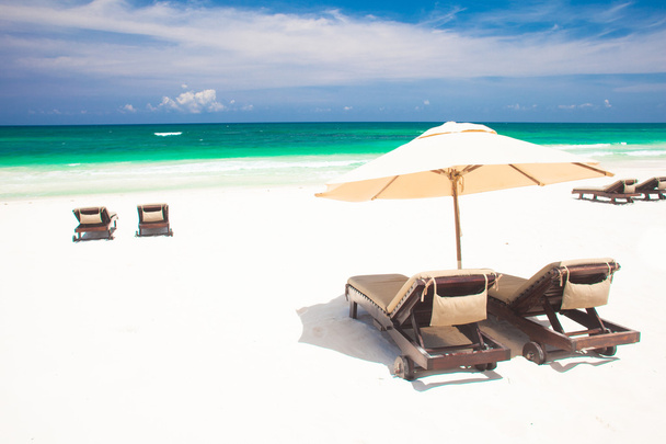 Multiple beach chairs and umbrella on sand beach. Holidays - Photo, Image