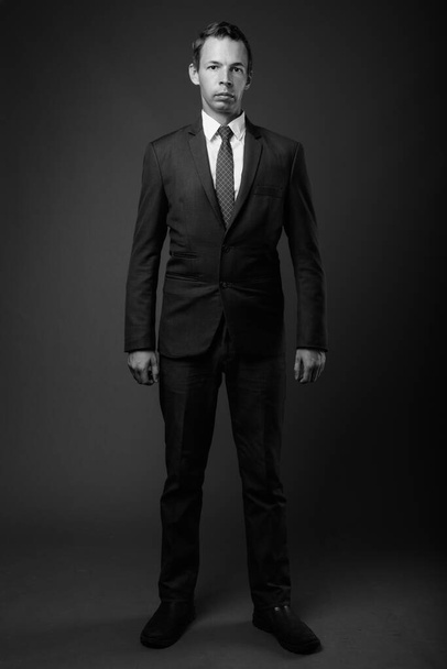 Studio shot of businessman against gray background - Foto, Imagem