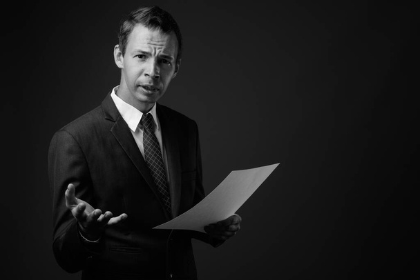 Studioaufnahme eines Geschäftsmannes vor grauem Hintergrund - Foto, Bild