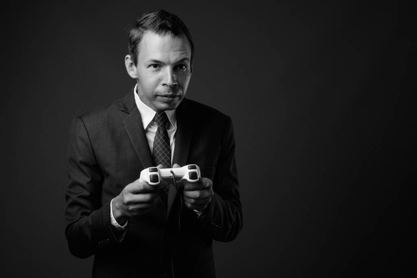 Studio shot of businessman against gray background - Foto, afbeelding