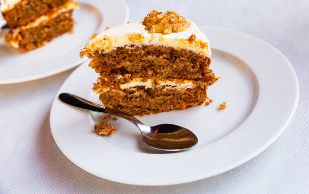 Slice of soft carrot cake with cream cheese glaze on wooden table - Foto, immagini