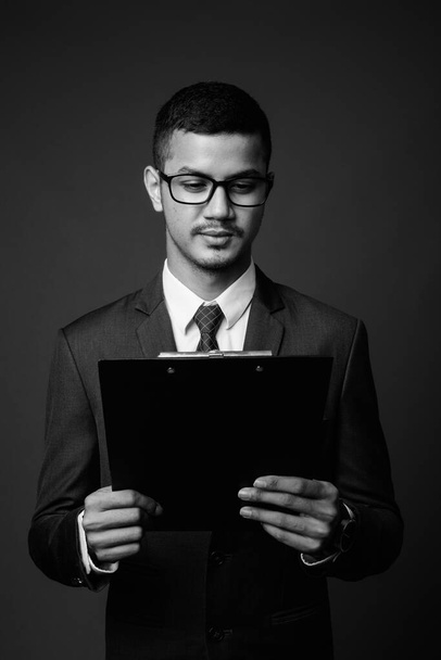 Giovane multi etnico asiatico uomo d'affari in giacca e cravatta contro sfondo grigio - Foto, immagini