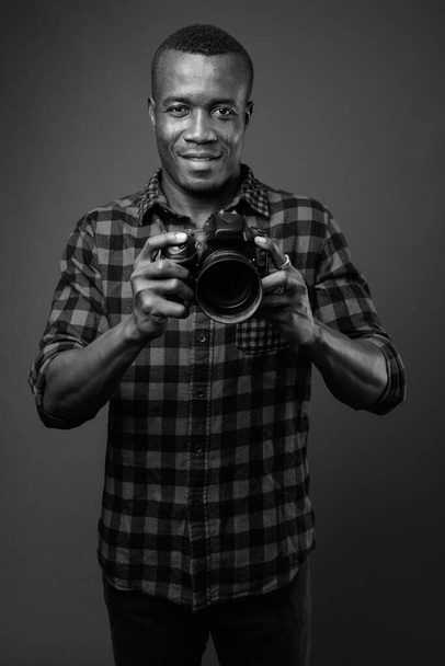 Studio shot of young African hipster man against gray background - Photo, Image