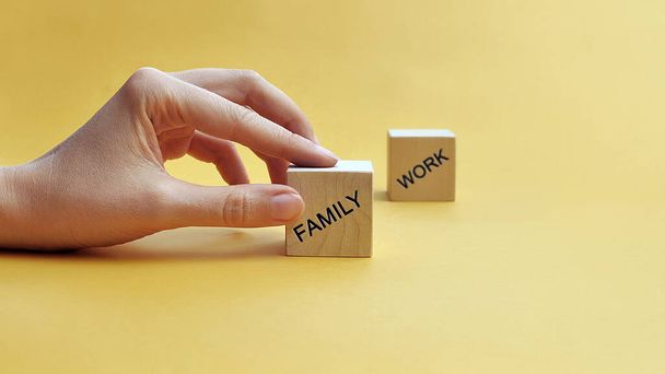 Drewniane bloki z napisem: Rodzina i praca. Wybieraj między rodziną a pracą. Preferencje rodzinne - Zdjęcie, obraz