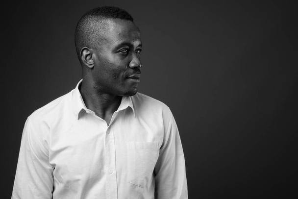 Studio záběr mladý africký podnikatel proti šedé pozadí - Fotografie, Obrázek