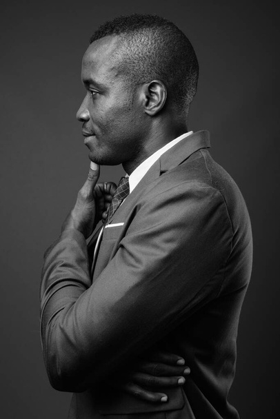 Studio záběr mladý africký podnikatel proti šedé pozadí - Fotografie, Obrázek
