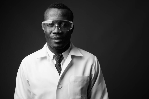 Στούντιο πλάνο του νεαρού Αφρικανού άνδρα γιατρό σε γκρι φόντο - Φωτογραφία, εικόνα