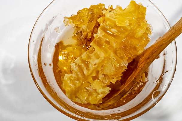 honeycomb honey in glass bowl with wooden spoon - Photo, Image