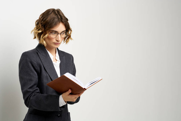 business woman in a suit with documents in hands light background curly hair hairstyle - 写真・画像