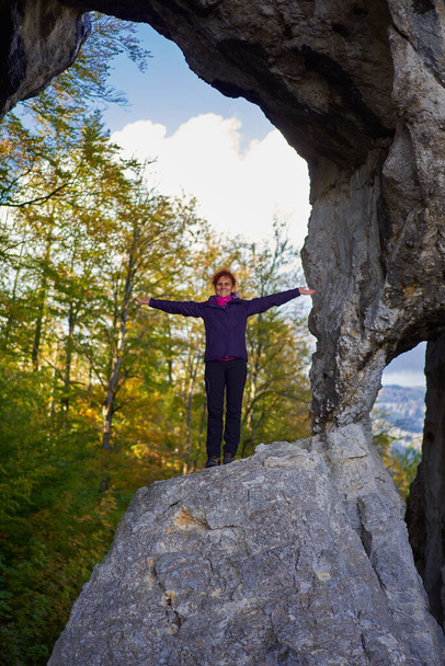 Woman hiker standing on the edge of a cliff in a doline - Foto, imagen