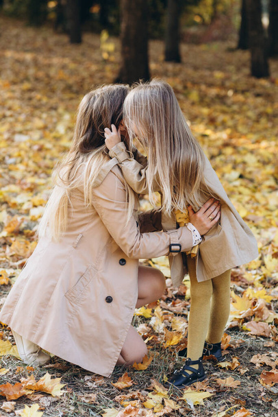 Happy mother and her beautiful daughter have fun and walk in the autumn park. - Fotografie, Obrázek