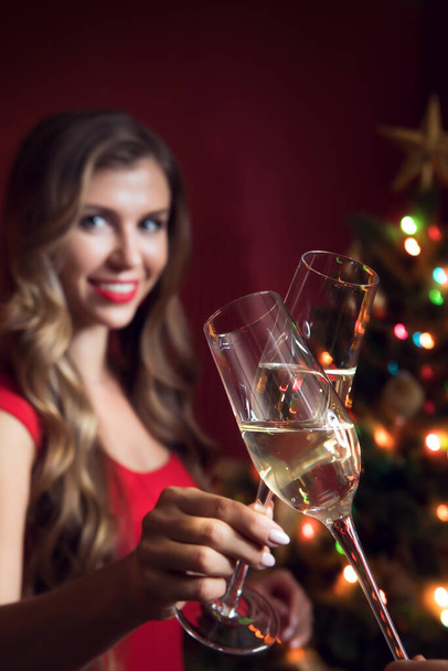 portrait de belle femme en robe rouge avec champagne dans l'environnement de Noël - Photo, image