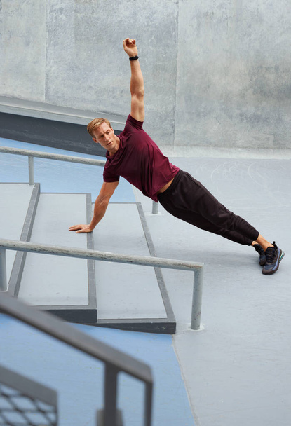 Young Man Doing Plank Near Concrete Steps Outdoors. Handsome Caucasian Sportsman With Strong Muscular Body In Fashion Sportswear Warming Up Before Intense Workout. - Fotografie, Obrázek