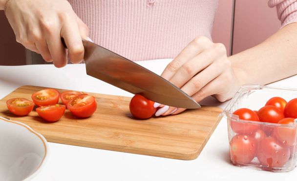 Slicing red cherry tomatoes on a wooden Board. - Φωτογραφία, εικόνα